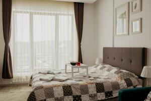 a bedroom with a bed with a table and a window at Milmari L29 in Kopaonik