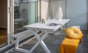 une table blanche et un banc dans une pièce dans l'établissement Meerzicht-Laguna, à Knokke-Heist