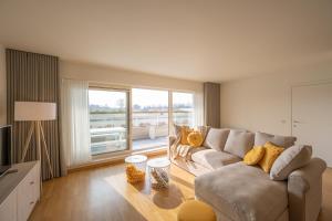a living room with a couch and a large window at Meerzicht-Laguna in Knokke-Heist
