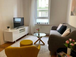 a living room with a couch and a tv at Zentrumsnahe schöne Altbauwohnung bis 4 Personen in Flensburg