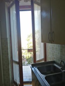a kitchen with a sink and a large window at Casa Argentina in Capoliveri