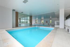 a large swimming pool with blue water in a building at Meerzicht-Laguna in Knokke-Heist