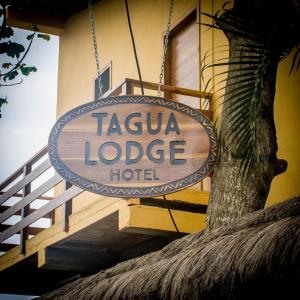 a sign for a taja lodge hotel hanging from a building at Tagualodge Hostel Manglaralto in Manglaralto