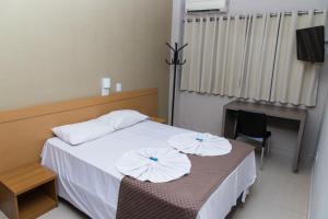 um quarto com uma cama com duas almofadas em Hotel Astória Maringá em Maringá