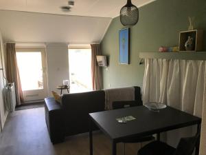 een woonkamer met een bank en een tafel bij De Deelderij in Schoonloo