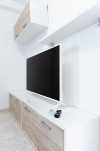 sala de estar con TV en una pared blanca en EDIFICIO CHAPARIL en Nerja