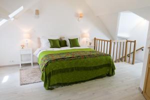 Un dormitorio con una cama grande con una manta verde. en Band of Brothers House, en Sainte-Marie-du-Mont