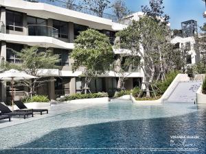 a swimming pool in front of a building at VERANDA HUAHIN BY LUX in Hua Hin