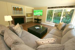 un soggiorno con un divano e una TV di Reflections! Seasonal Dock & Kayaks!! Hot Tub!! Fire Table! BBQ! HUGE yard! Horseshoes! Dog Friendly! a Guerneville