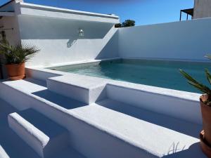 una piscina al lado de una casa blanca en Alojamiento con Encanto Armenia, en Alcalá de los Gazules