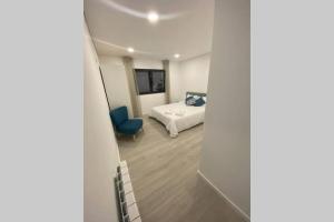 ein Schlafzimmer mit einem Bett und einem blauen Stuhl in einem Zimmer in der Unterkunft Barcelos Views T3 in Barcelos