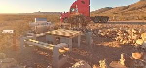 een picknicktafel en een truck in een veld bij Camping at Desert Gardens Oasis at Lobo, Texas in Van Horn