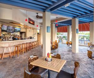 ein Restaurant mit einem Tisch und Stühlen sowie einer Bar in der Unterkunft Kona Coast Resort in Kailua-Kona