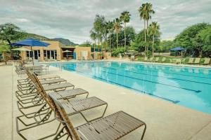 a large swimming pool with chairs and umbrellas at Starr Pass Golf Suites in Tucson