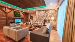 a living room filled with furniture and a tv at Hotel Crocus in Vysoké Tatry