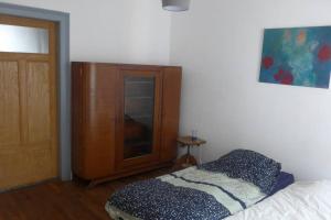 Un dormitorio con una cama y un armario de madera. en gite herbes folles, en Lutzelbourg
