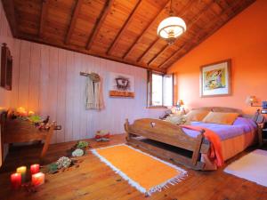 1 dormitorio con paredes de color naranja, 1 cama y velas en Belvilla by OYO Cas do Mestre, en San Salvador