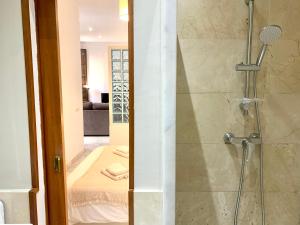 a bathroom with a shower with a glass door at Homely Málaga Pozos Dulces 27 centro histórico in Málaga +65 photos