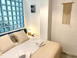 a bedroom with a bed with two towels on it at Homely Málaga Pozos Dulces 27 centro histórico in Málaga