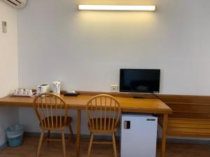 a desk with two chairs and a computer on it at Beaconsfield Lodge Motel in Beaconsfield