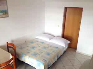 een slaapkamer met een bed, een tafel en een deur bij Apartment in Rtina/Zadar Riviera 8160 in Miočić