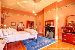 a living room with a bed and a fireplace at Buxton Manor in Adelaide