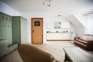 a living room with a couch and a kitchen at Pensjonat Bogdanka in Trzęsacz