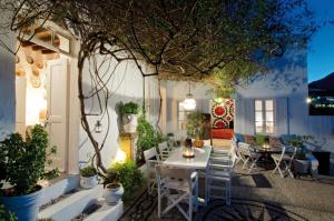 d'une terrasse avec une table, des chaises et un arbre. dans l'établissement Villa Melenos Lindos, à Lindos