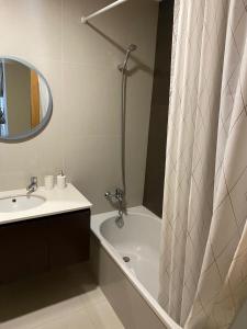 a bathroom with a sink and a shower curtain at Sol Poente Praia Apartment in Apúlia