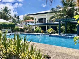 a swimming pool in front of a house at Suite Princess Beach Resort in Siquijor