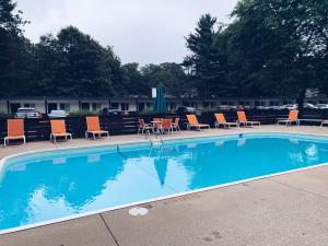 uma grande piscina com cadeiras e mesas em Starlite Resort em Saugatuck