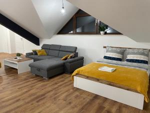 sypialnia z łóżkiem i kanapą w obiekcie Apartament Rynek 13 z parkingiem - Centrum Bochni w mieście Bochnia