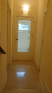 a hallway with a white door with a window at 534 Petit San Telmo - Studio & Suites in Buenos Aires