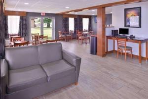 a living room with a couch and a table and chairs at SureStay Hotel by Best Western Bowling Green North in Bowling Green