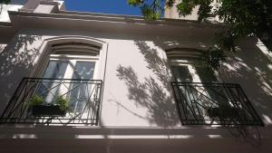 534 Petit San Telmo - Studio & Suites في بوينس آيرس: بيت ابيض مع نافذه وشرفه
