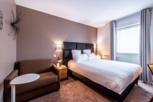 - une petite chambre avec un lit et une chaise dans l'établissement Best Western Plus Au cheval Blanc à Mulhouse, à Baldersheim