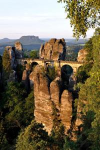 uma ponte sobre um penhasco nas montanhas azuis em Landhotel Zum Erbgericht em Stolpen