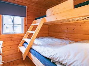um quarto com um beliche num chalé de madeira em 4 person holiday home in Assens em Assens