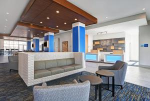 a lobby of a hotel with chairs and a bar at Holiday Inn Express & Suites Memorial – CityCentre, an IHG Hotel in Houston