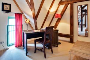 a room with a desk and a chair with a lamp at Gasthaus und Pension "Zum Hauenden Schwein" in Wörlitz