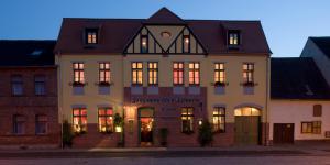a large white building with lights on at Gasthaus und Pension "Zum Hauenden Schwein" in Wörlitz