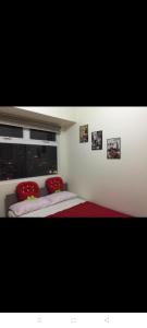 a bedroom with two beds with red pillows and a window at Urban Deca Tower @ Graceysplace Unit 4 Mandaluyong in Manila