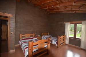 - 2 lits dans une chambre dotée de murs en bois dans l'établissement Cabaña El Ensueño, à Tapalpa