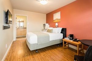 a bedroom with a bed and a desk with a television at Parlee Beach Motel in Shediac