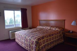 a hotel room with a bed and a window at PLYMOUTH MOTOR LODGE in Terryville