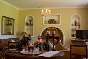 a living room with a table and a chandelier at Gerald's Gift Guest House in Addo