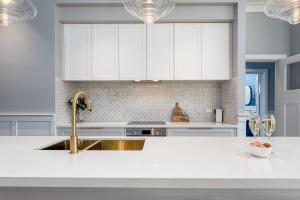 une cuisine avec des armoires blanches et un évier dans l'établissement Marysville Luxury Villa, à Marysville 33 autres photos