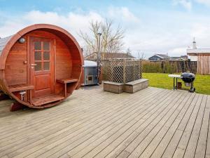 een klein houten hobbithuis op een houten terras bij 6 person holiday home in Hejls in Hejls