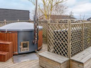 een hot tub op een terras met een hek bij 6 person holiday home in Hejls in Hejls