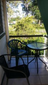 a table and a chair on a porch with a table at Baringa Bed & Breakfast in Redcliffe